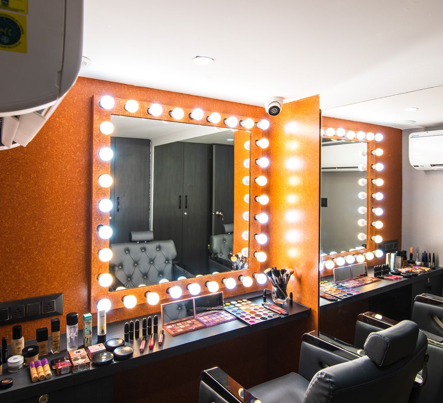 The make-up stations at Ftry Salon: two bulb-lit mirrors above a counter of products.